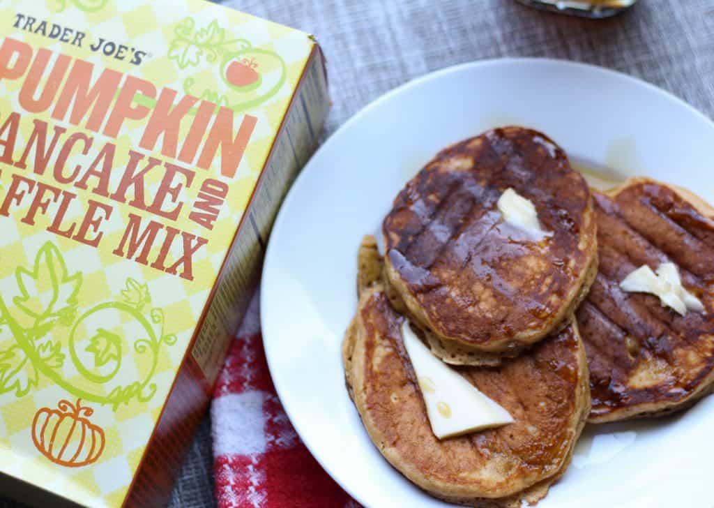 Trader Joe's Pumpkin Pancake and Waffle Mix fully cooked with butter and syrup next to the original box.