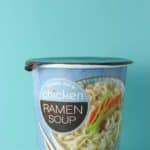 An unopened container of Trader Joe's Chicken Ramen Soup on a blue background