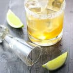 Cadillac Margarita fully prepared with empty shot glass, limes, and salt
