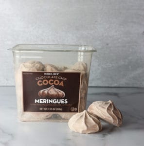 An open box of Trader Joe's Chocolate Chip Cocoa Meringues with two meringues out for display