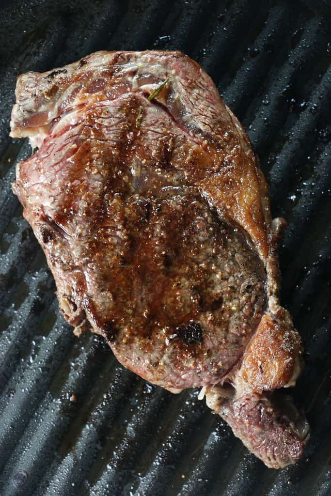 A grilled ribeye steak on a grill pan