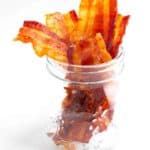 Bacon Jerky in a small mason jar on a white surface