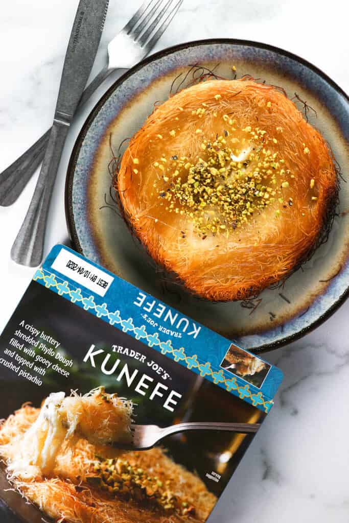 A fully baked Trader Joe's Kunefe on a plate with a fork and knife next to the plate