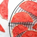 Dehydrated watermelon on a wire rack with two dried slices off to the side