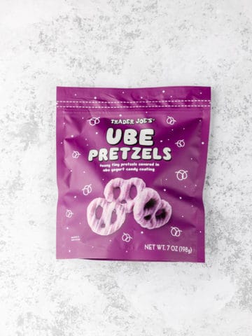 An unopened bag of Trader Joe's Ube Pretzels on a grey surface.