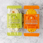Two Trader Joe's Egg Bites varieties on a grey surface.