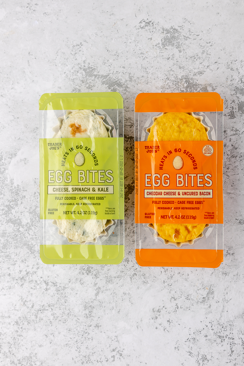 Two Trader Joe's Egg Bites varieties on a grey surface.