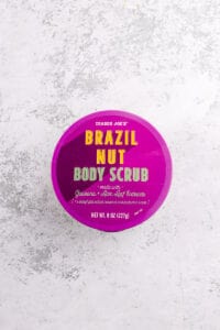 An unopened package of Trader Joe's Brazil Nut Body Scrub on a grey surface.