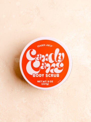 Trader Joe's Candy Cane Body Scrub unopened on a pink surface.