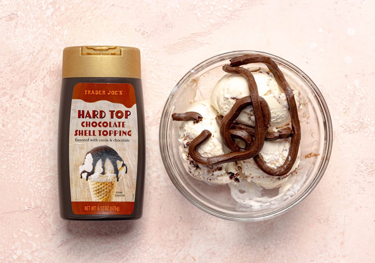 Trader Joe's Hard Top Chocolate Shell Topping on some vanilla ice cream with the original container next to the bowl.