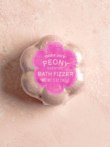 An unopened Trader Joe's Peony Scented Bath Fizzer on a pink surface.