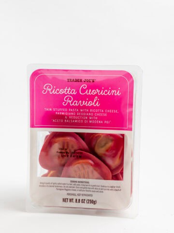 An unopened package of Trader Joe's Ricotta Cuoricini Ravioli on a grey surface.