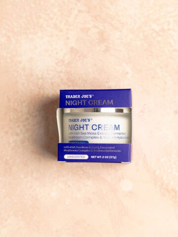 An unopened package of Trader Joe's Night Cream on a pink surface.