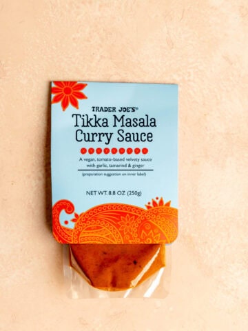 A Trader Joe's Tikka Masala Curry Sauce on a pink surface.