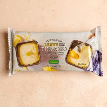 An unopened Trader Joe's Lemon Tiramisu on a pink surface.