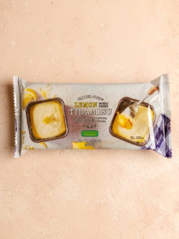 An unopened Trader Joe's Lemon Tiramisu on a pink surface.