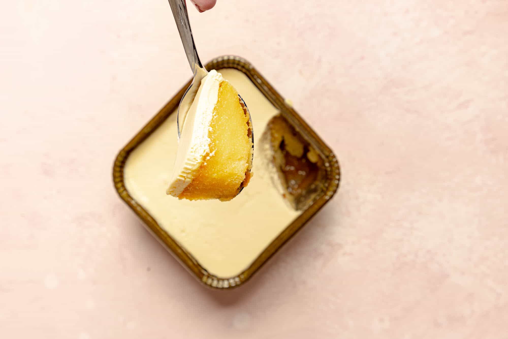 An opened and defrosted Trader Joe's Lemon Tiramisu on a pink surface.