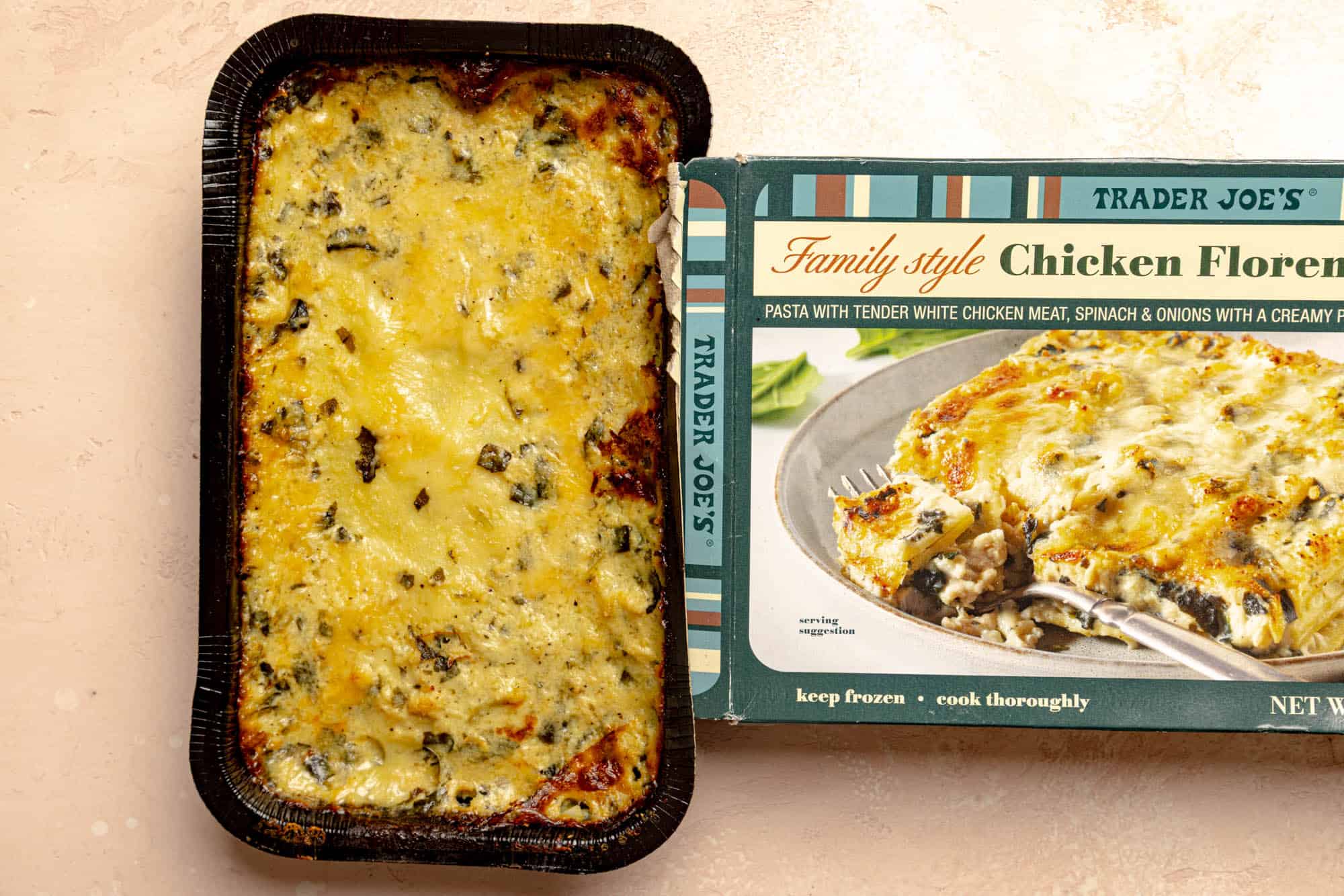 A fully baked Trader Joe's Family Style Chicken Florentine Lasagna next to the original box.