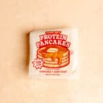 Trader Joe's Protein Pancakes unopened on a pink surface.