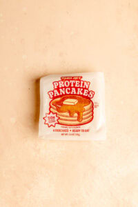 Trader Joe's Protein Pancakes unopened on a pink surface.