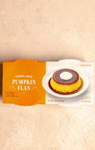 An unopened package of Trader Joe's Pumpkin Flan on a pink surface.