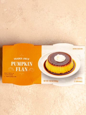 An unopened package of Trader Joe's Pumpkin Flan on a pink surface.